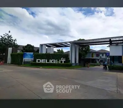 Modern residential entrance with stylish architecture and lush greenery.