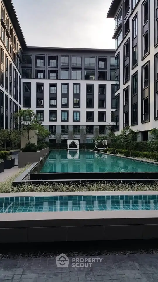 Modern apartment complex with a luxurious swimming pool and stylish architecture.