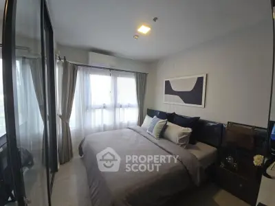Cozy modern bedroom with large window and stylish decor in a contemporary apartment.