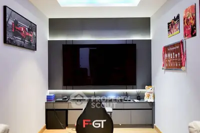 Modern entertainment room with sleek TV setup and gaming chair, perfect for relaxation and gaming enthusiasts.