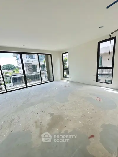 Spacious unfurnished room with large windows and natural light