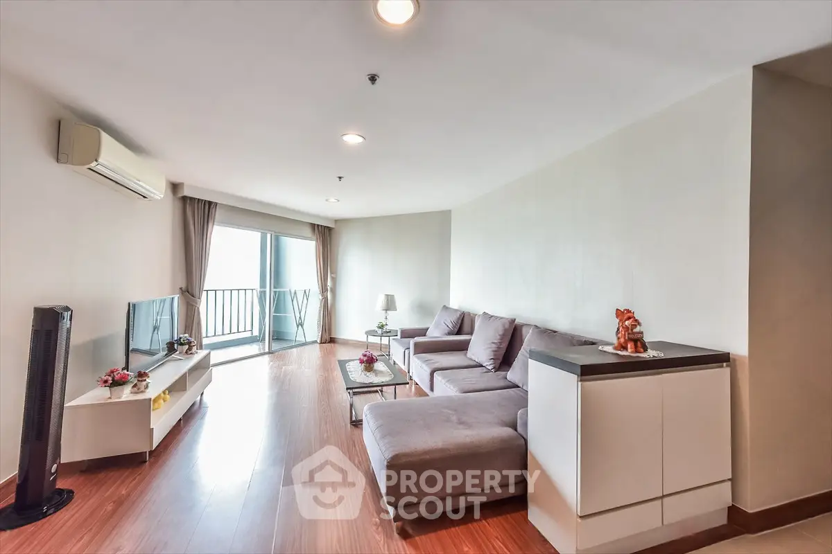 Spacious living room with modern decor and balcony access