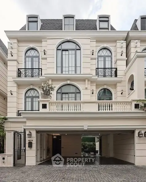 Elegant three-story building with classic architecture and gated entrance, perfect for luxury living.