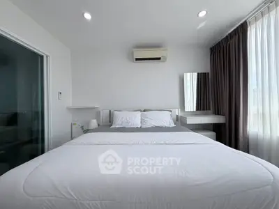 Modern bedroom with white bedding, air conditioning, and natural light from large windows.