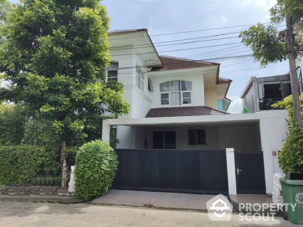 Charming two-story house with lush greenery and modern design in a serene neighborhood.