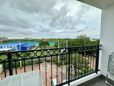 Stunning balcony view overlooking lush greenery and urban landscape.