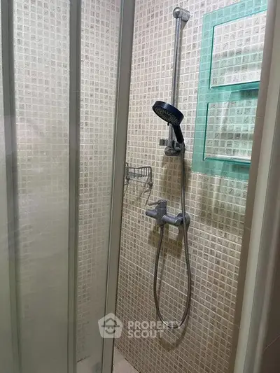 Modern shower area with glass doors and tiled walls in a contemporary bathroom.