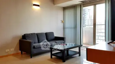 Modern living room with sleek furniture and balcony view in urban apartment.