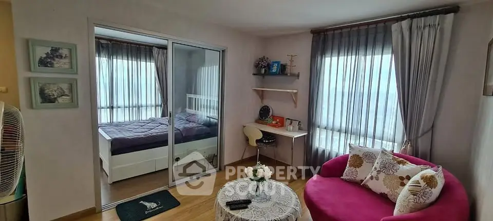 Charming apartment interior with cozy living room and stylish bedroom separated by glass doors.