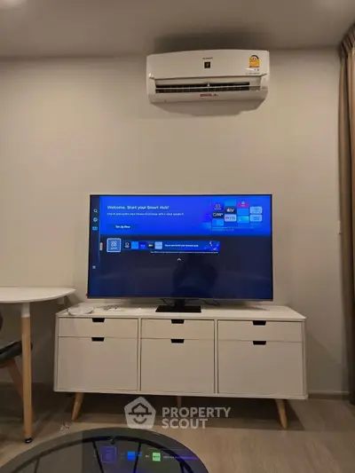 Modern living room with sleek TV setup and air conditioning unit