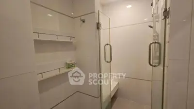 Modern bathroom with glass shower and sleek white tiles