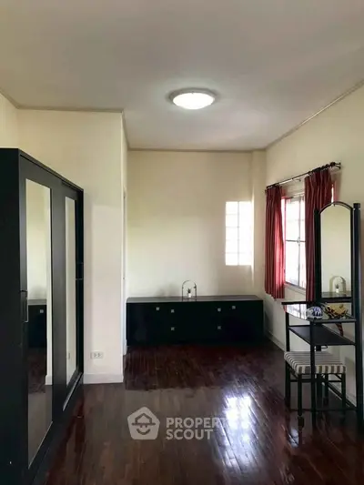 Spacious bedroom with elegant wooden flooring and stylish furniture