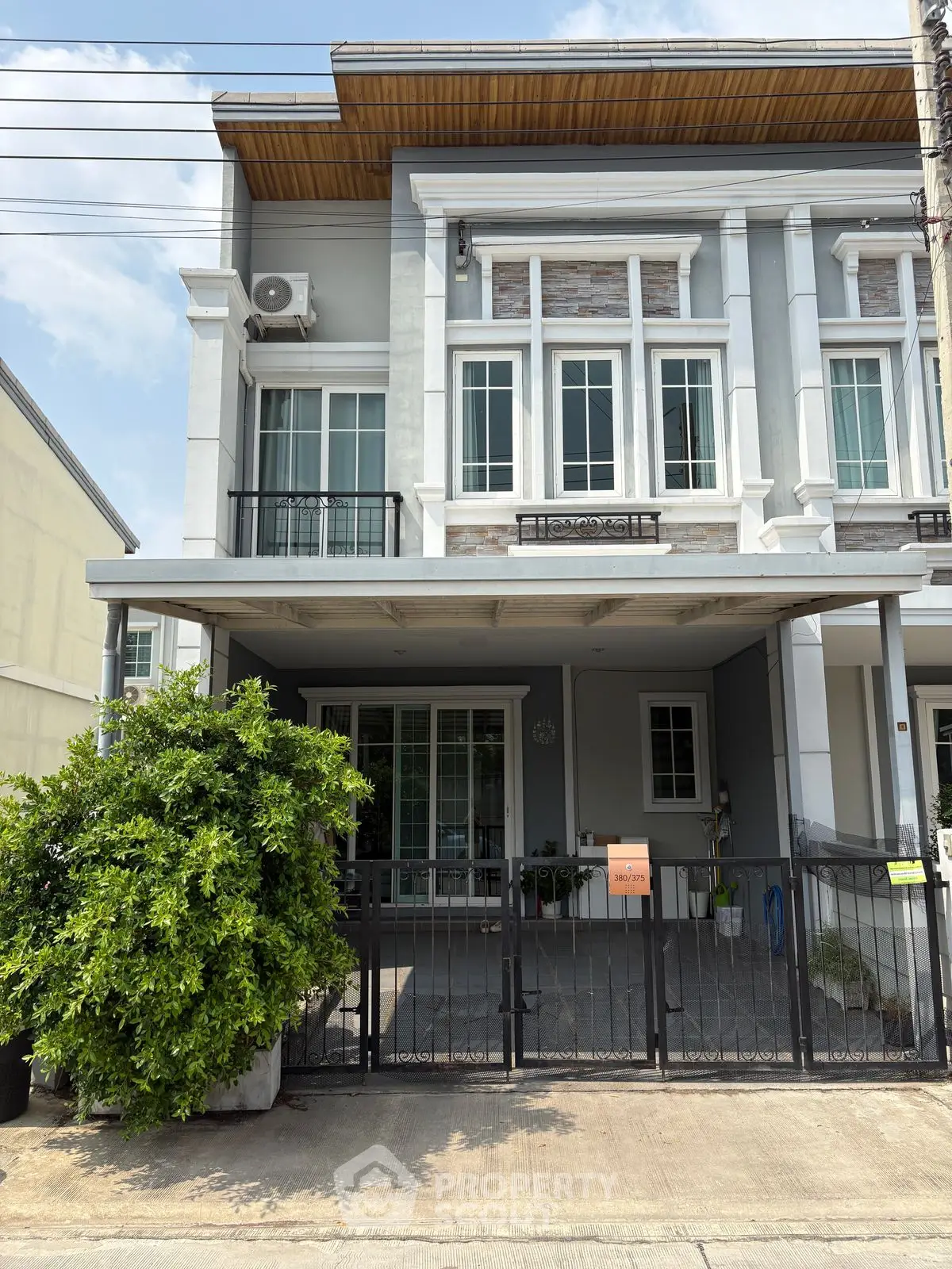 Charming townhouse with modern facade and gated entrance in a serene neighborhood.
