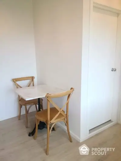 Cozy corner dining area with wooden chairs and white table in modern apartment