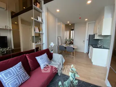 Modern open-plan living room with stylish kitchen and dining area, featuring elegant decor and cozy seating.