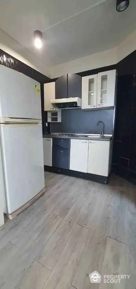 Modern kitchen with sleek cabinets and spacious fridge in stylish apartment