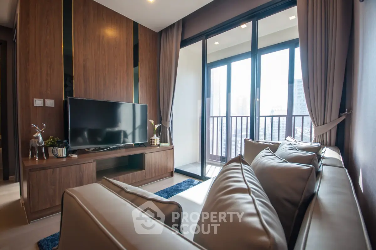 Modern living room with large windows and balcony view in a stylish apartment.