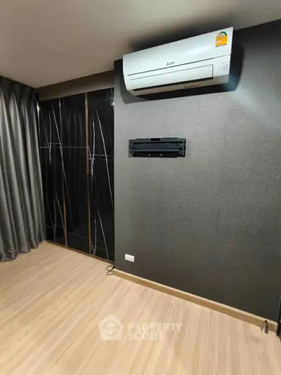 Modern interior with sleek black wardrobe and air conditioning unit, perfect for stylish living.