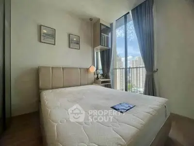 Modern bedroom with large windows offering stunning city views in a high-rise apartment.