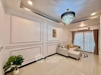 Elegant living room with chandelier, modern sofa, and stylish decor in a bright, spacious setting.