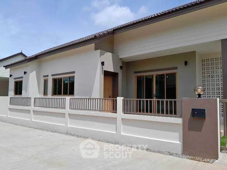 Modern single-story house with a sleek design and fenced front yard, perfect for family living.