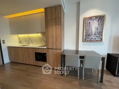 Modern kitchen with sleek cabinetry and dining area in contemporary apartment.