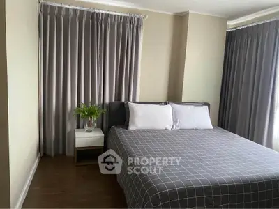 Cozy bedroom with modern decor and large windows for natural light.