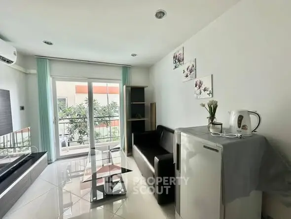 Modern living room with sleek furniture and balcony view, perfect for urban living.