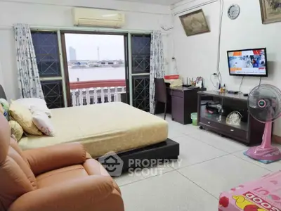 Cozy bedroom with city view, featuring a comfortable bed, TV, and seating area.
