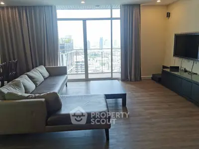 Spacious living room with city view and modern furnishings in high-rise apartment
