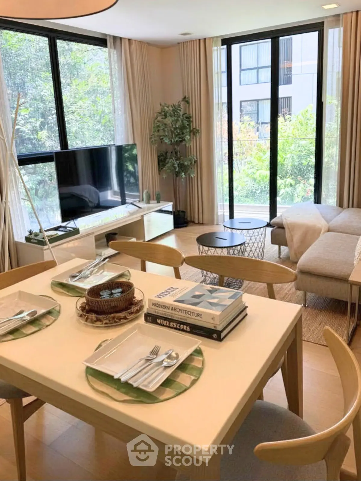 Stylish living room with modern decor, large windows, and a cozy dining area in a contemporary apartment.