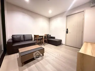 Modern living room with sleek furniture and wooden flooring in a cozy apartment.