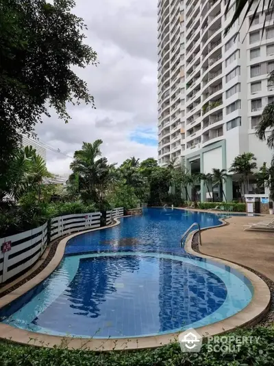 Luxurious high-rise building with stunning pool and lush greenery