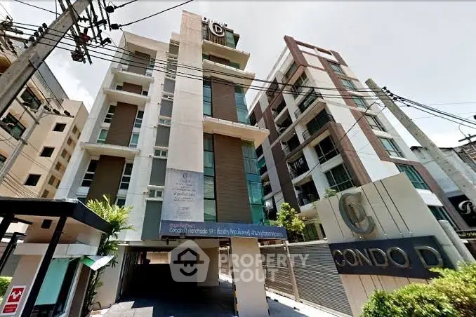 Modern condominium building exterior with sleek design and urban appeal in prime location.