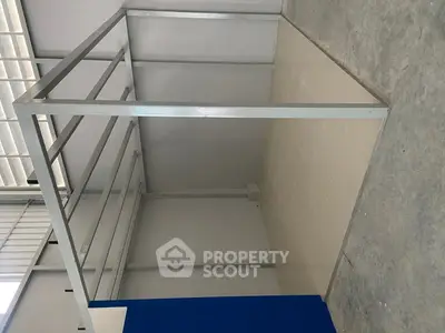 Spacious industrial-style storage area with metal framework and tiled flooring.