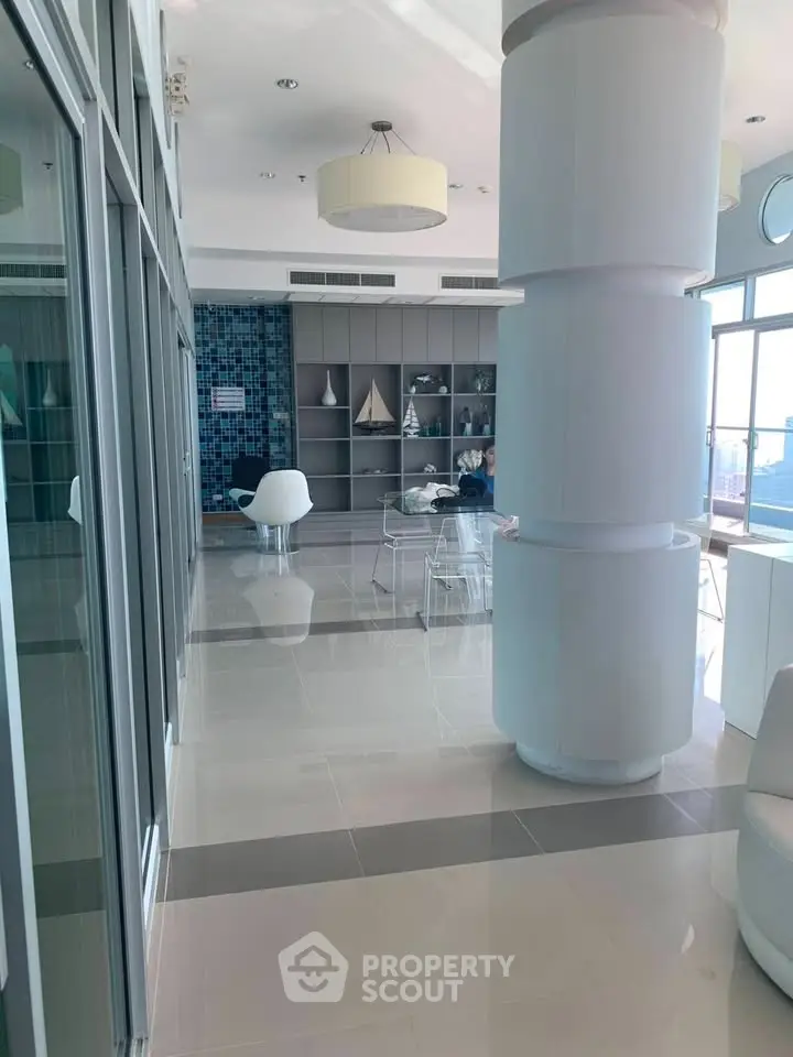 Modern living room with sleek design and large windows offering natural light.