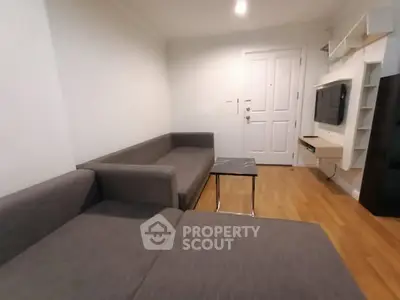 Modern living room with sleek gray sofas and wall-mounted TV