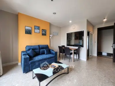 Modern living room with stylish decor and open dining area in a contemporary apartment.