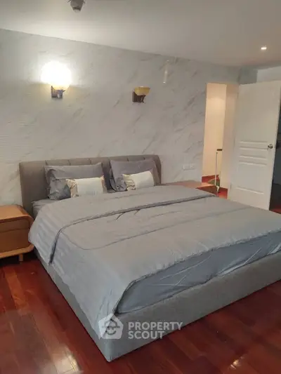 Spacious bedroom with elegant decor and cozy ambiance, featuring a plush bed and stylish lighting.