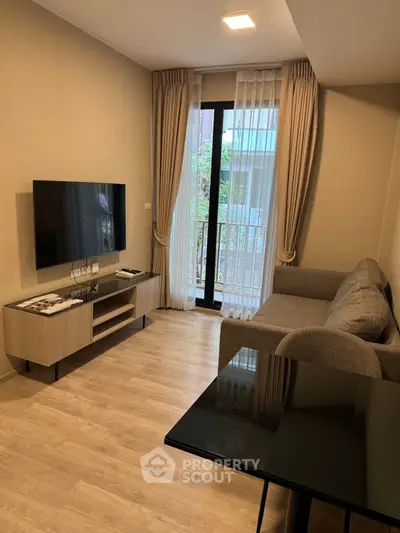 Modern living room with sleek TV setup and cozy sofa, featuring elegant curtains and wooden flooring.