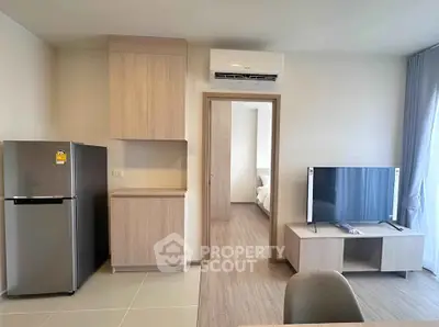 Modern apartment interior with sleek kitchen and cozy living area featuring a TV and air conditioning.