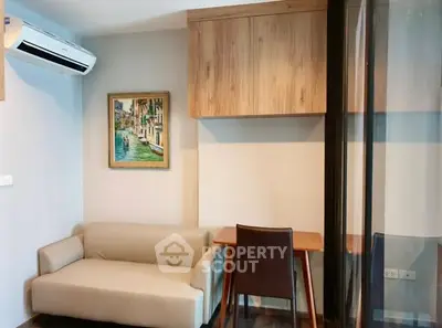 Modern living room with compact sofa, wall-mounted air conditioner, and stylish wooden furniture.