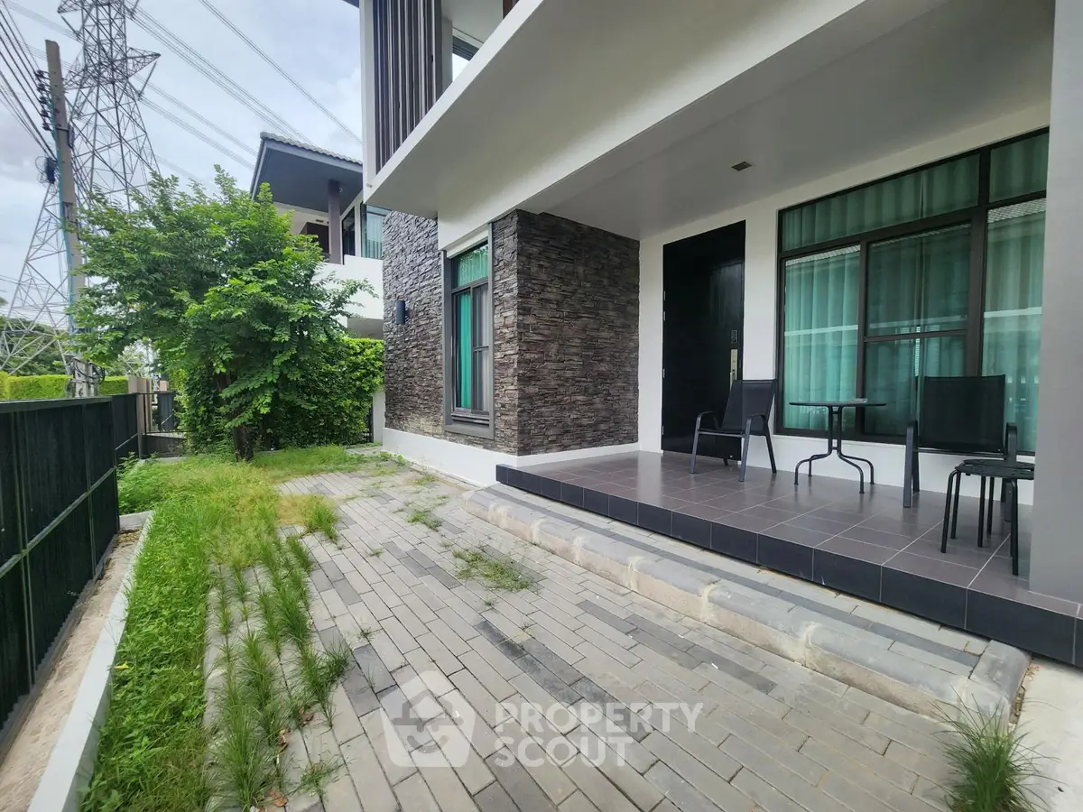 Modern house exterior with patio and lush greenery, perfect for relaxation and outdoor enjoyment.