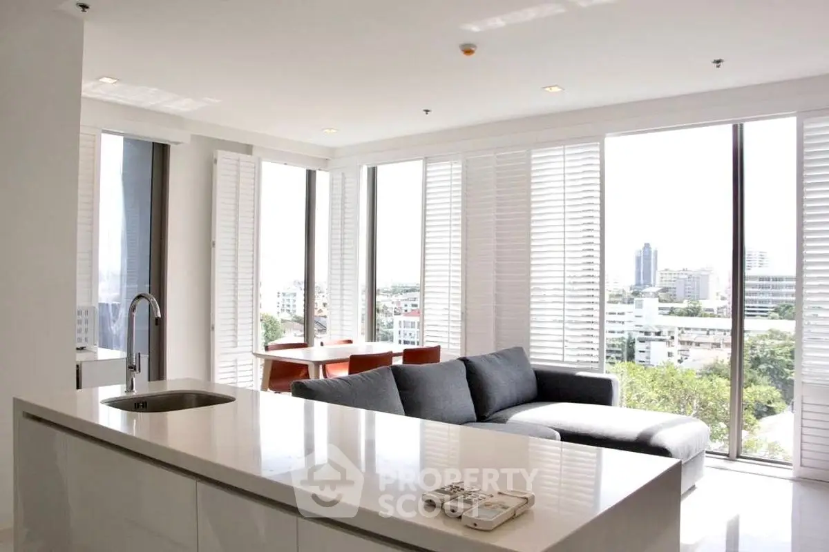 Stunning modern living room with panoramic city views and sleek open kitchen layout.