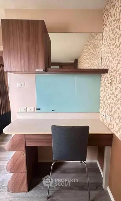 Modern study area with stylish desk and chair, featuring a decorative wall and ample storage.