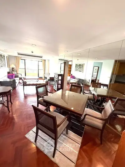 Spacious dining area with elegant wooden flooring and large windows in a modern apartment.