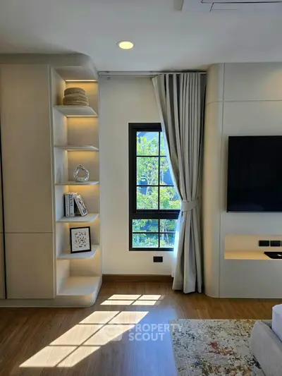 Modern living room with stylish shelving and large window for natural light