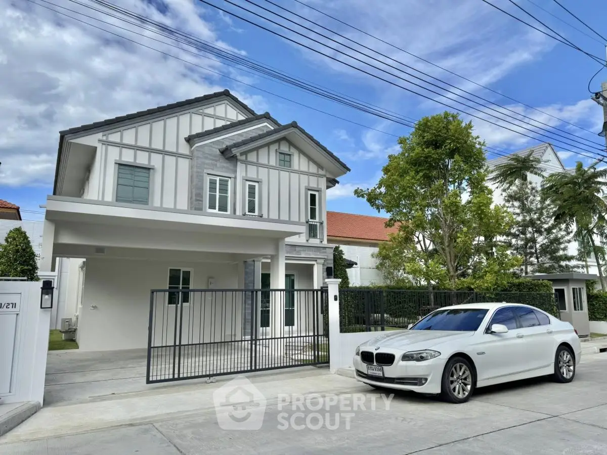 Modern two-story house with driveway and parked car in suburban neighborhood.