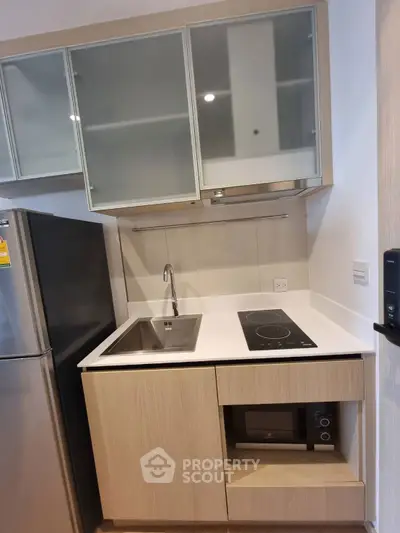 Modern compact kitchen with sleek cabinetry and built-in appliances