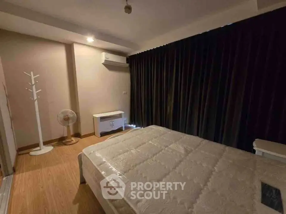 Cozy bedroom with modern furnishings and dark curtains, perfect for restful nights.